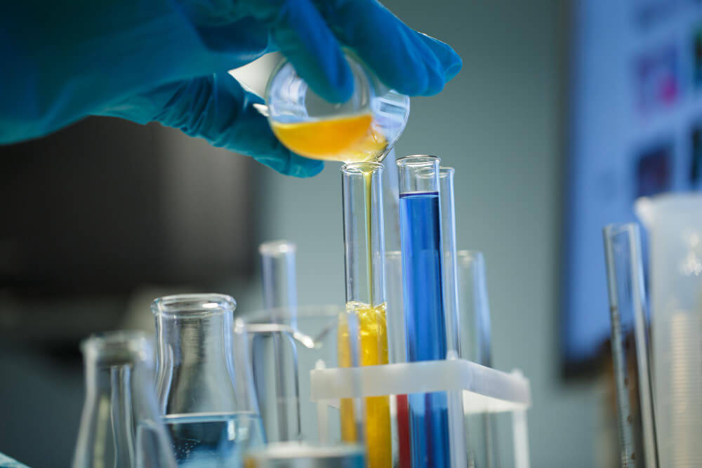 Técnico de laboratorio vertiendo una solución en un tubo de ensayo